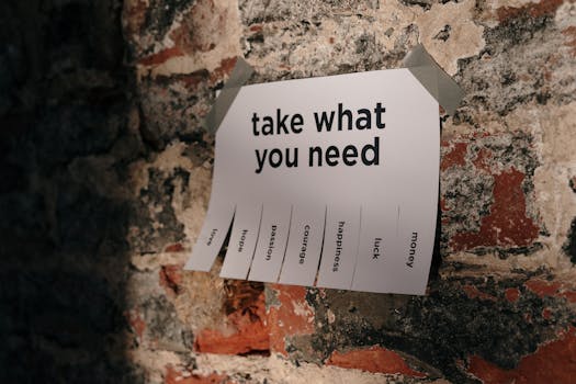 A motivational note offering positive qualities taped to a brick wall.